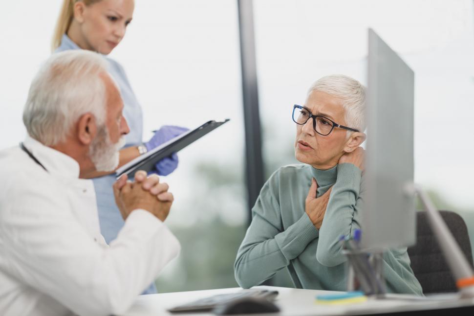 Free Image of Elderly patient discussing neck pain with doctor 