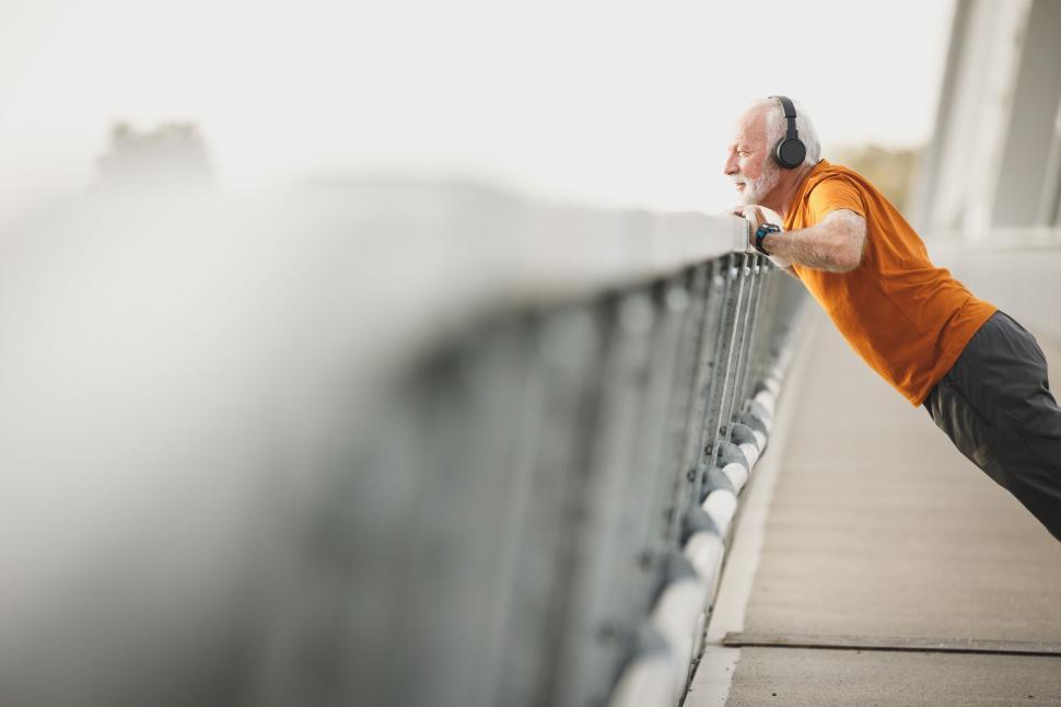 Free Image of Man stretching on a bridge during an outdoor workout 