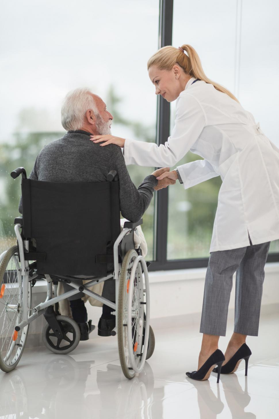 Free Image of Doctor providing comfort to a senior patient in wheelchair 