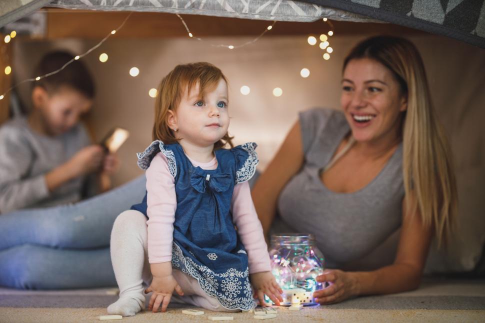 Free Image of Child playing in a homemade fort with mother 