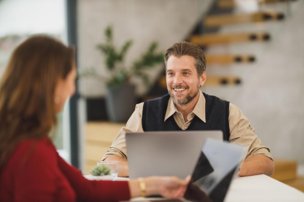 Free Image of Businessman smiling at colleague over a laptop 