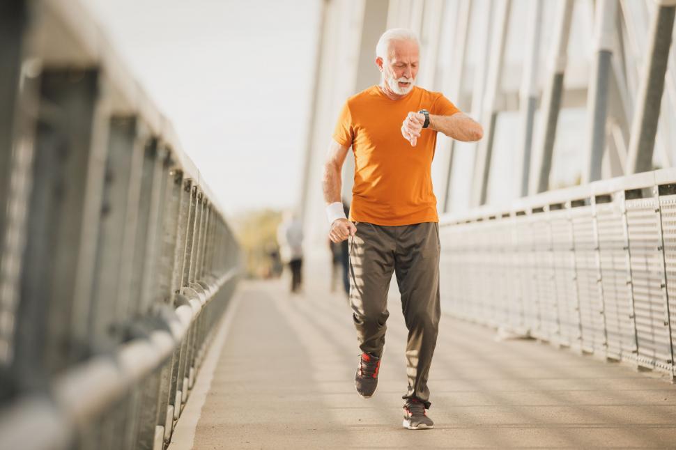 Free Image of Senior man running on a bridge during sunset 