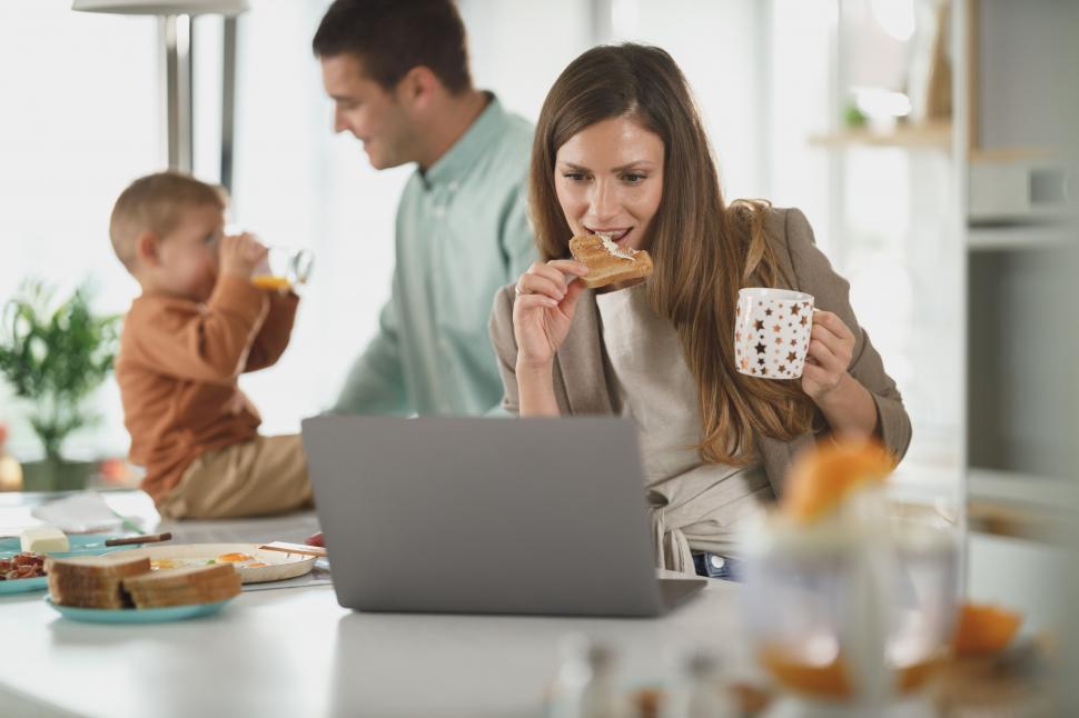 Free Image of Woman multi-tasking breakfast with work 