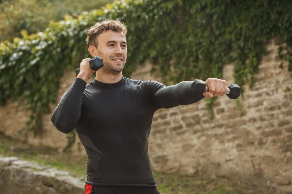 Free Image of Man exercising outdoors with weights 