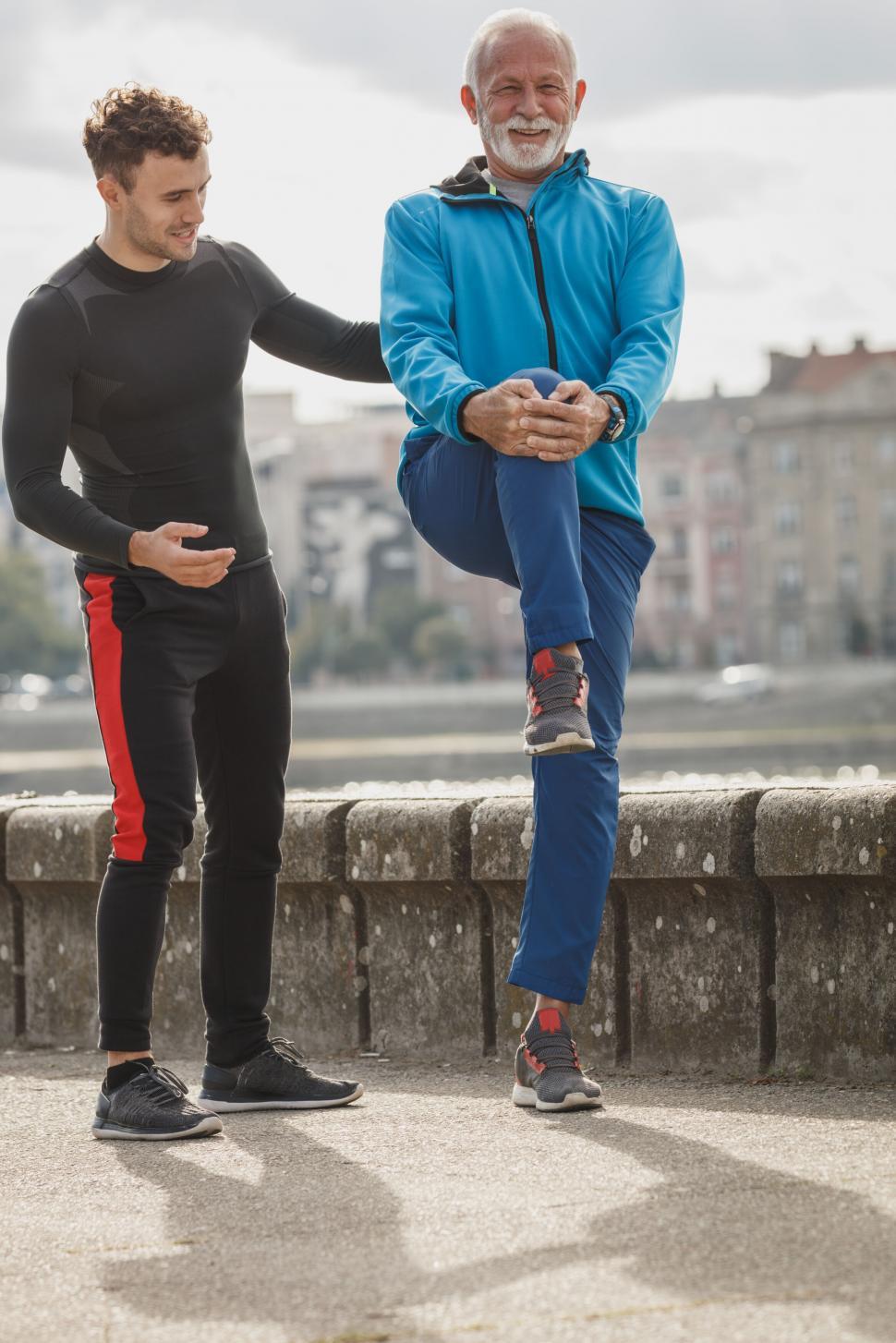 Free Image of Older man stretching with personal trainer 