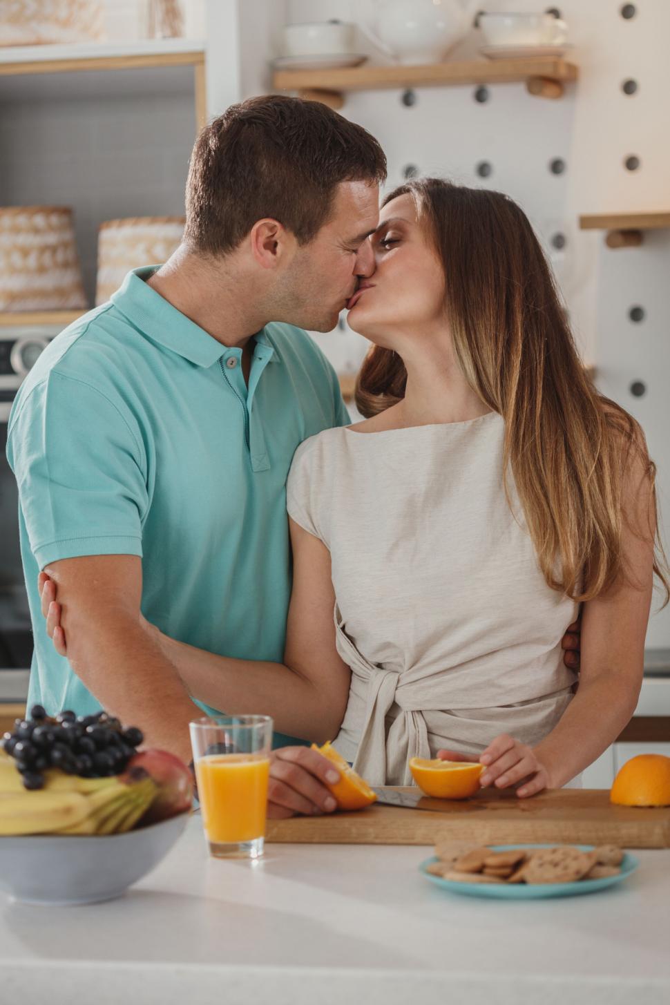 Free Image of Couple embracing while preparing breakfast 