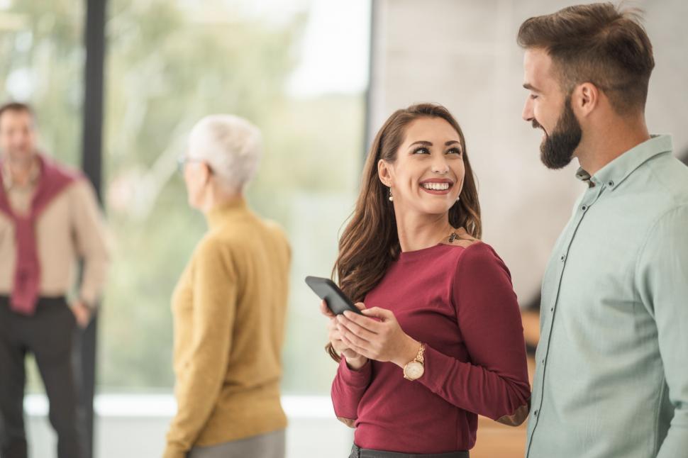 Free Image of Smiling woman flirting with colleague at work 