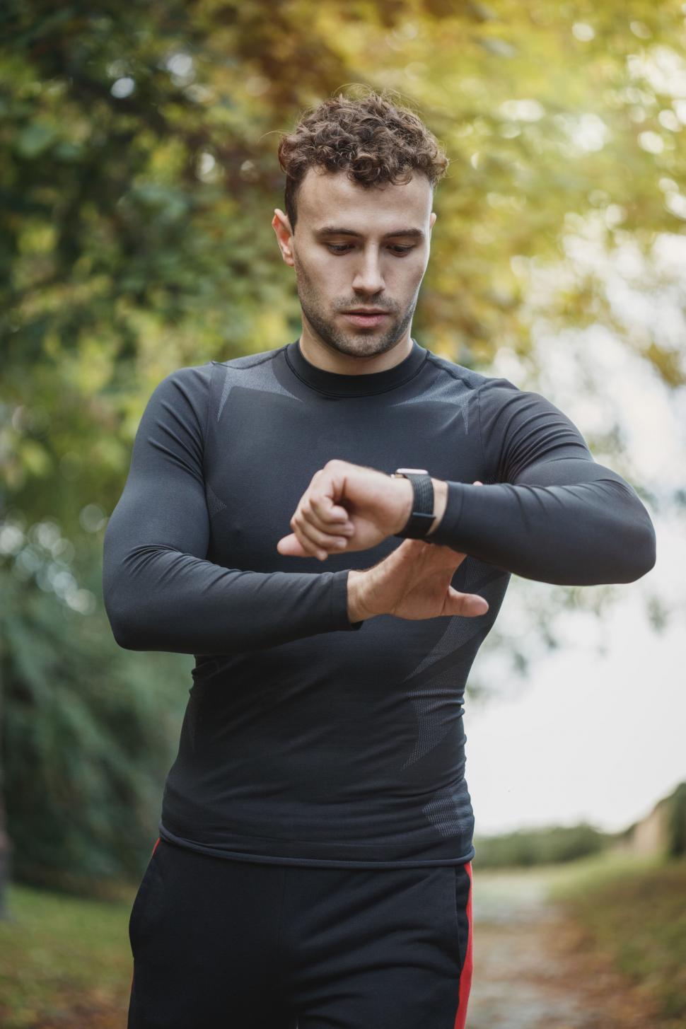 Free Image of Man checking smartwatch while exercising 