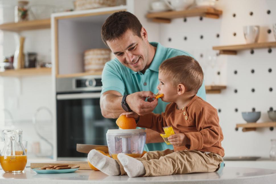 Free Image of Father and son bonding over fruit cutting 