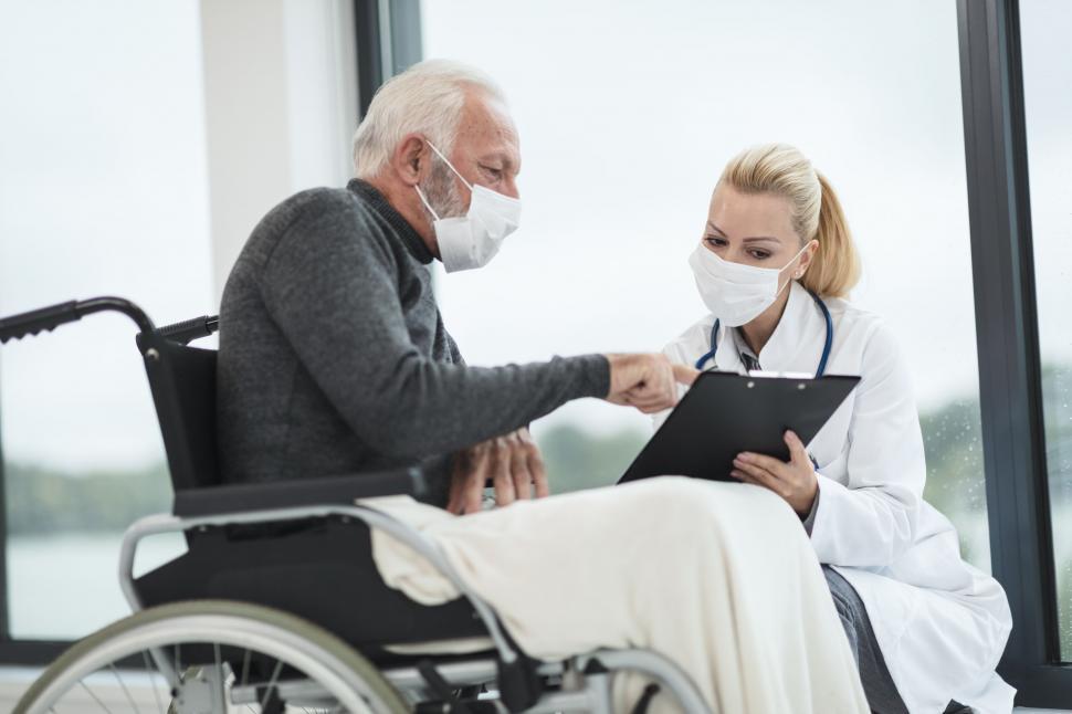 Free Image of Elderly man in wheelchair consulting doctor 