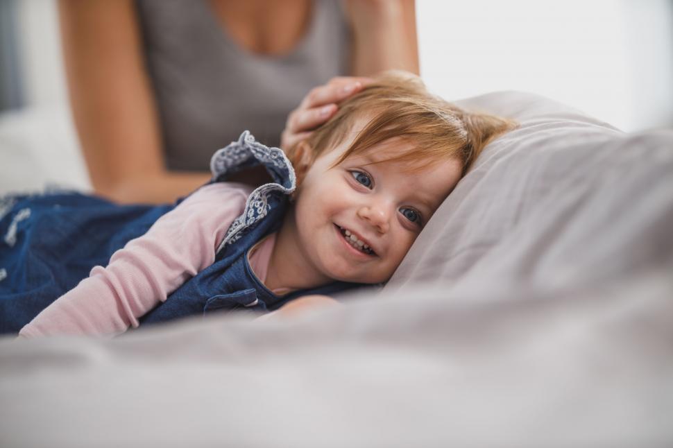 Free Image of Child lying on bed feeling unwell 