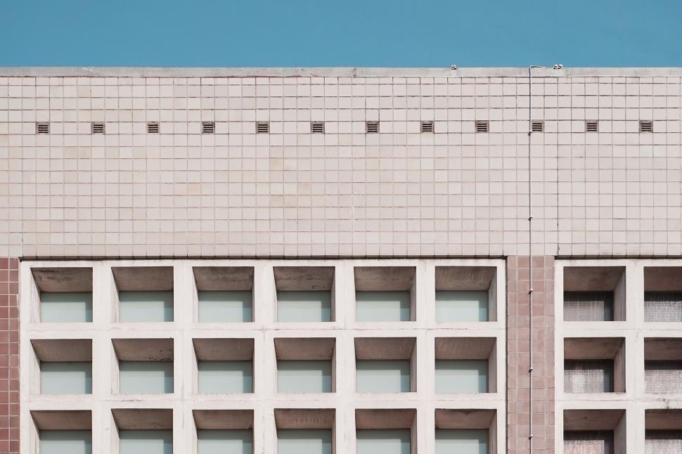 Free Image of Pink tiled building exterior with rhythmic windows 