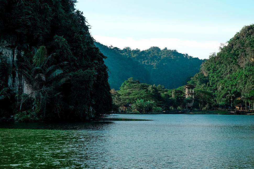 Free Image of Serene lake with pagoda and lush hills 