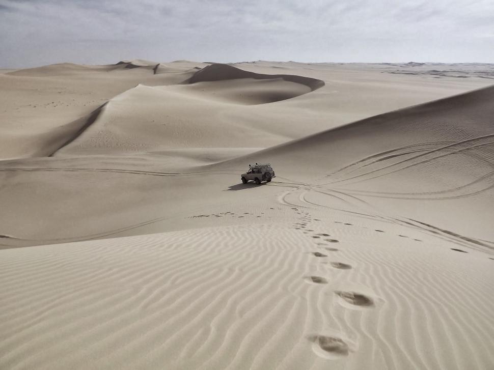 Free Image of Desolate desert landscape with a lone car 
