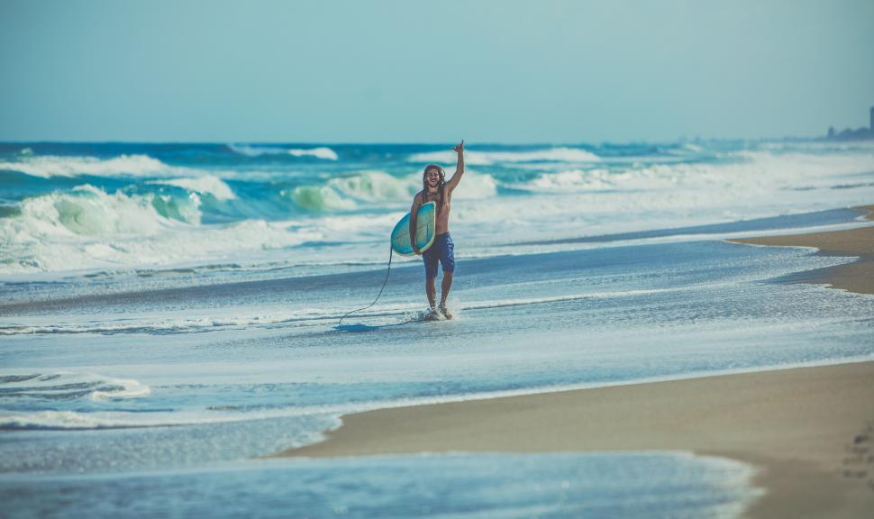Free Image of Child plays on the beach with waves 