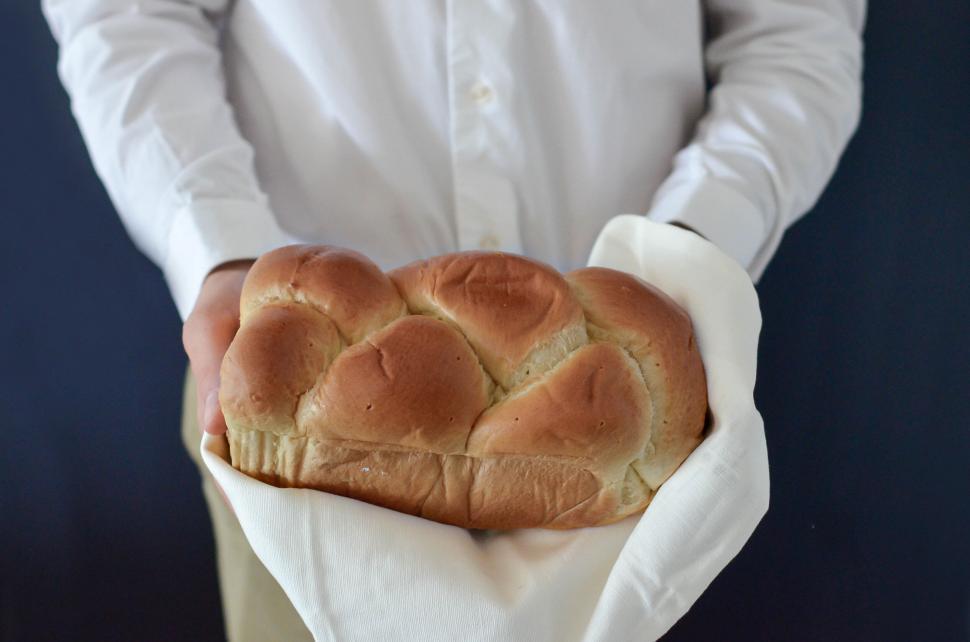 Free Image of Person holding freshly baked braided bread 