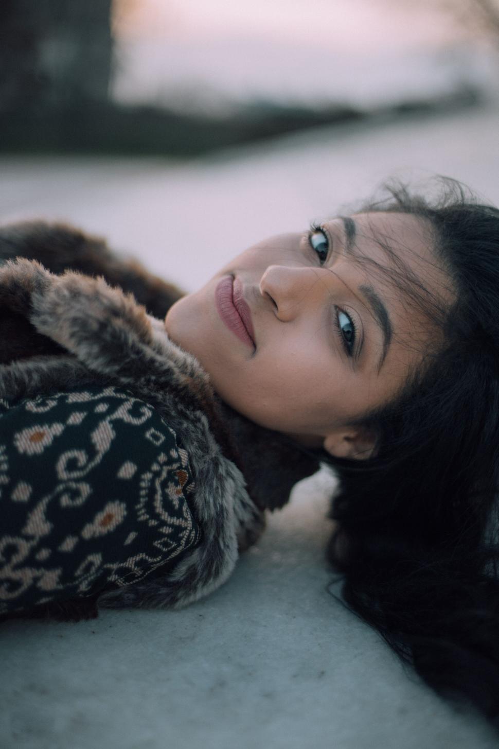 Free Image of Portrait of woman lying down with coat 