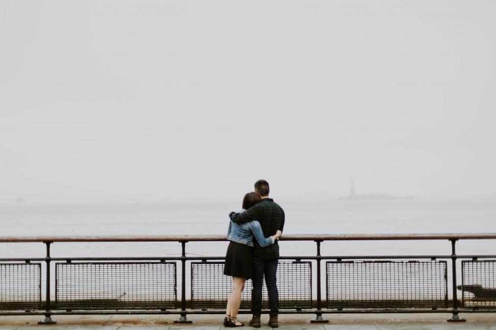 Free Image of Couple embracing overlooking misty waters 