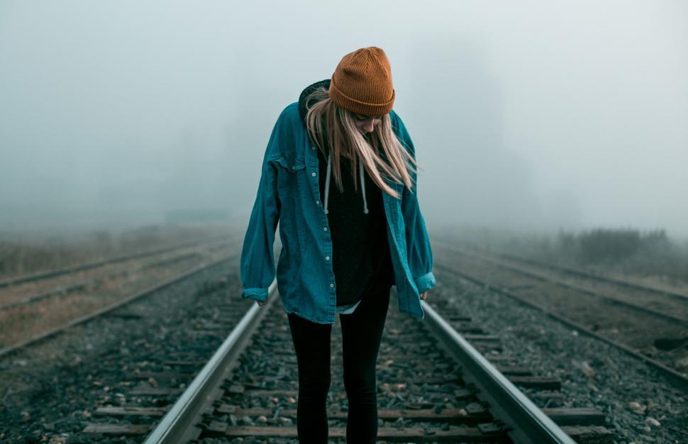 Free Image of Mysterious figure on foggy railroad tracks 