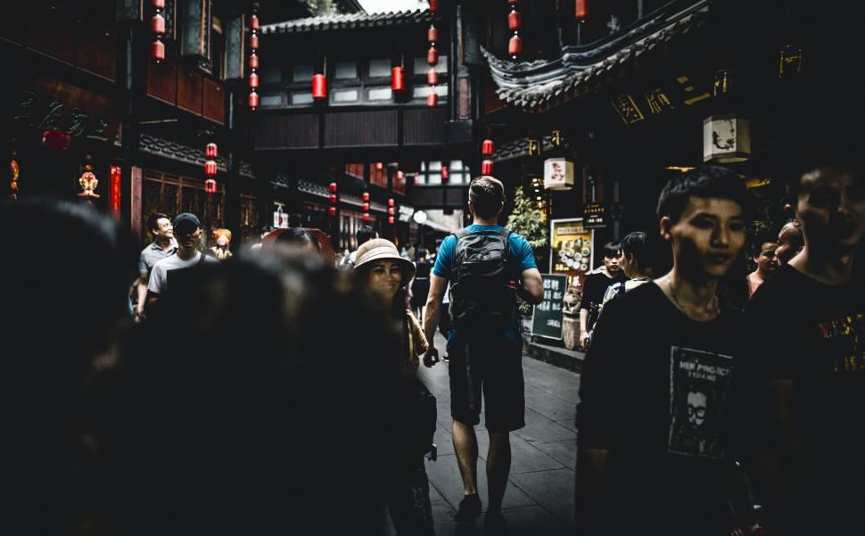 Free Image of Crowded street scene with focus on one person 