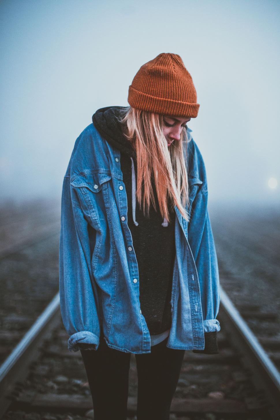 Free Image of Solitary individual on misty train tracks 