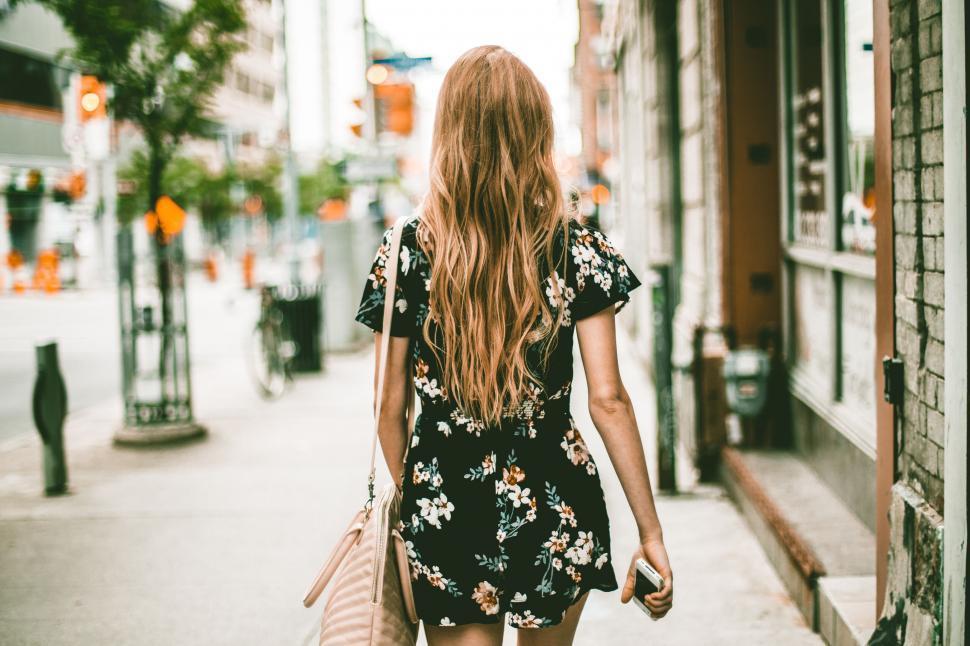 Free Image of Woman walking on a city sidewalk 