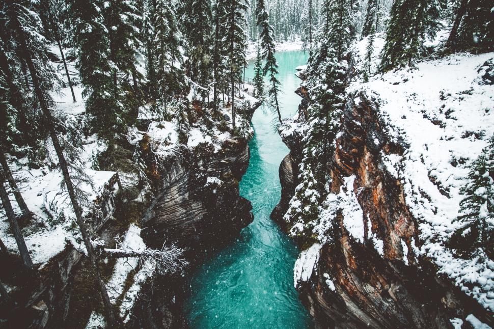 Free Image of Snowy canyon with a turquoise river in winter 