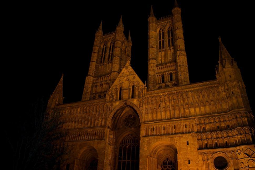 Free Image of Gothic Cathedral Illuminated at Night Against Dark Sky 