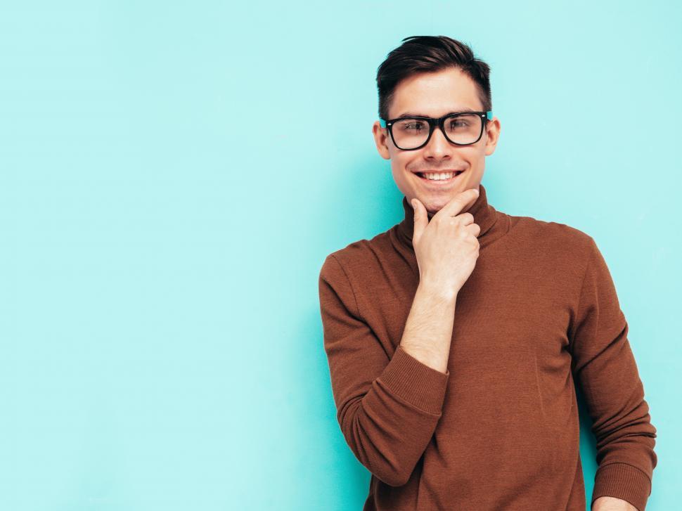 Free Image of A man wearing glasses and a brown sweater 