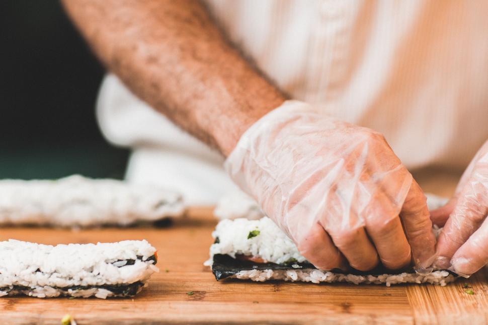 Free Image of Close up of hands making sushi rolls 