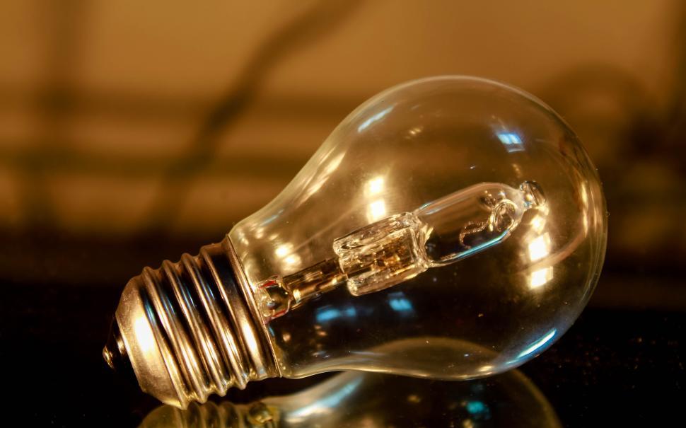 Free Image of Incandescent light bulb on reflective surface 