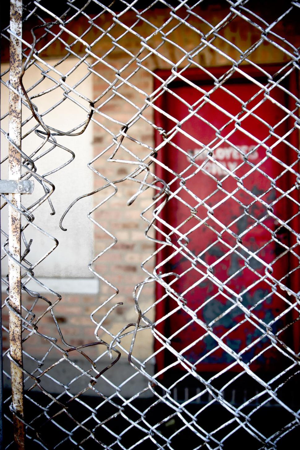 Free Image of Rusty chain-link fence with vibrant red background 