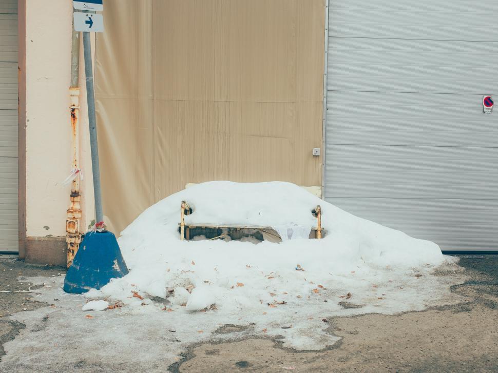 Free Image of Snow-covered bench in an urban setting 
