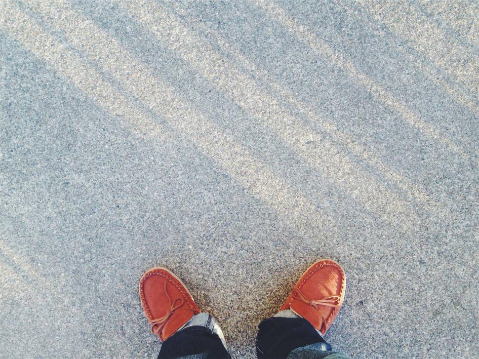 Free Image of Person s feet on sandy beach texture 