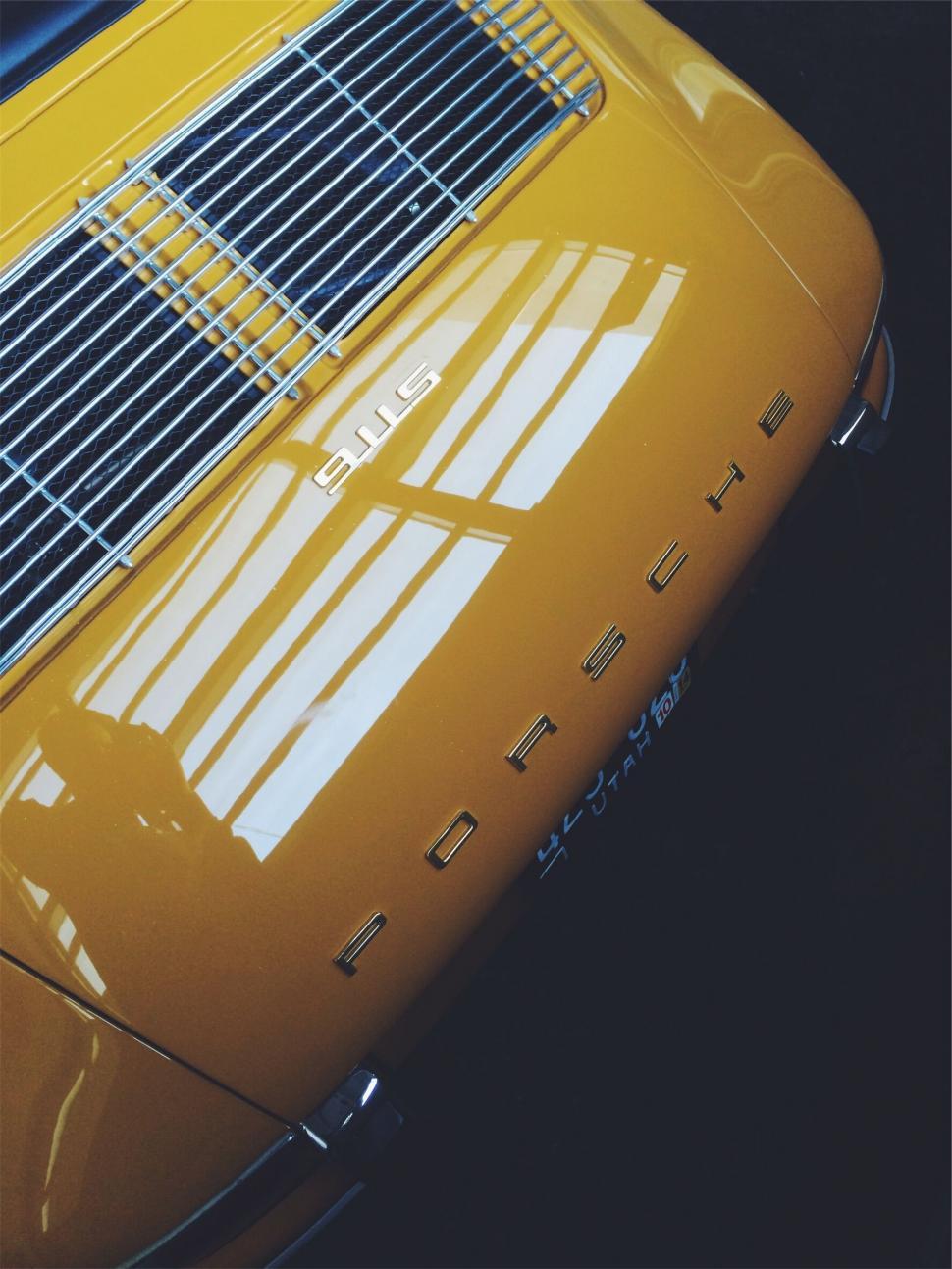 Free Image of Detail of a yellow Porsche car rear 