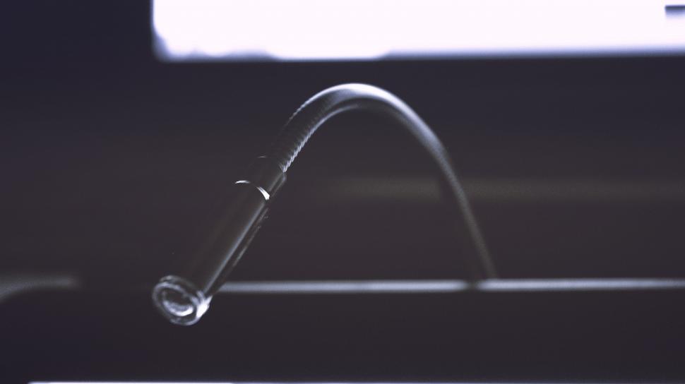 Free Image of Close-up of a flexible desk lamp against screen 