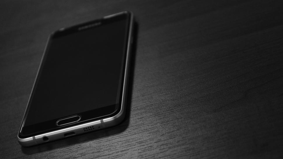 Free Image of Dark smartphone on wooden surface 