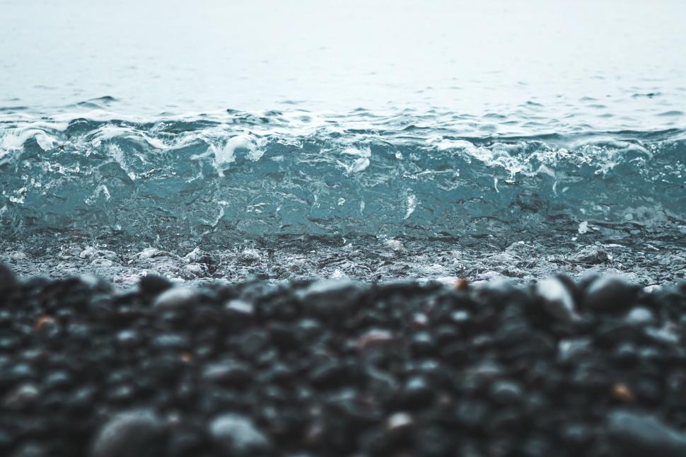 Free Image of Close-up of wave on pebbled shore 