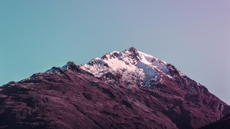 Free Image of Snow-capped mountain peak under pinkish sky 