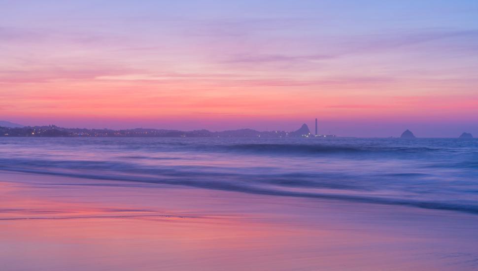 Free Image of Vibrant beach sunset with sweeping waves 