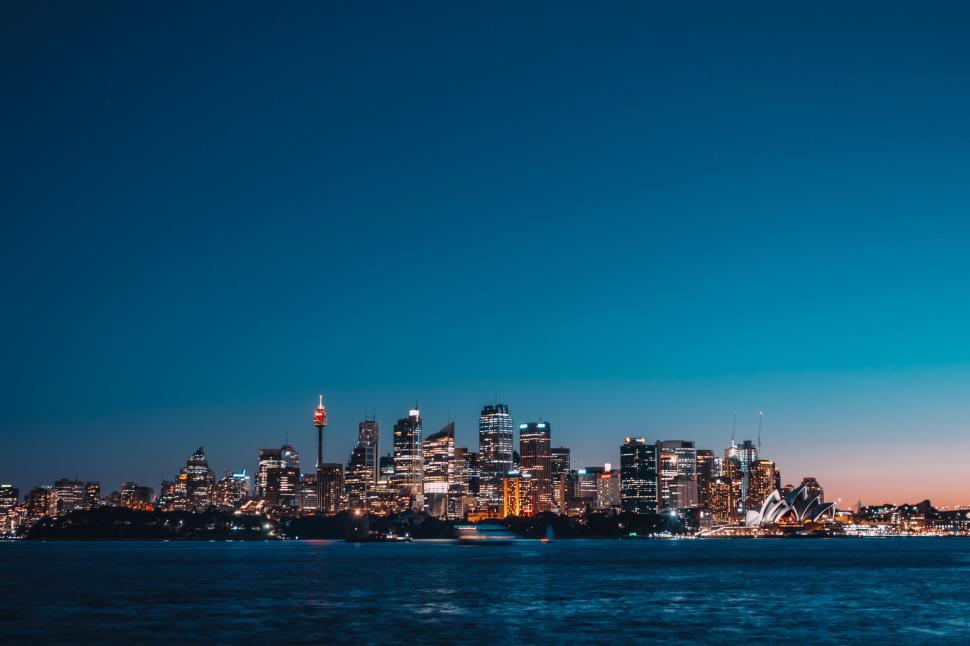 Free Image of Twilight city skyline over tranquil water 