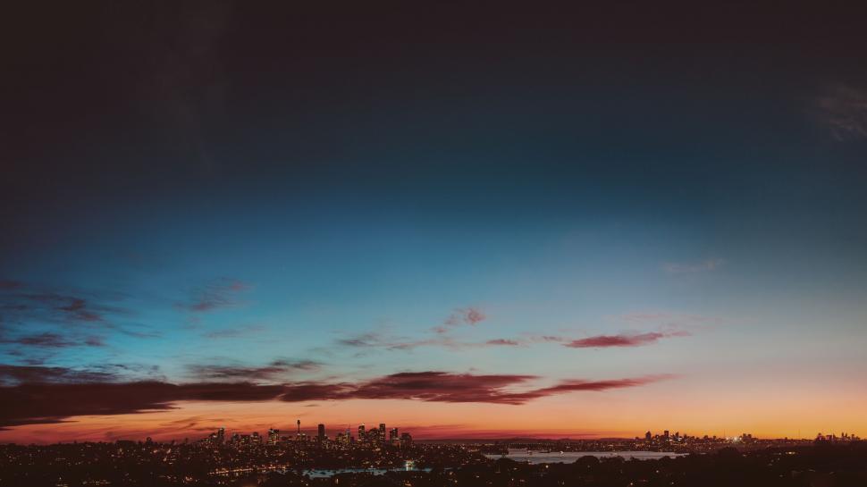 Free Image of Sunset glows behind a panoramic urban view 