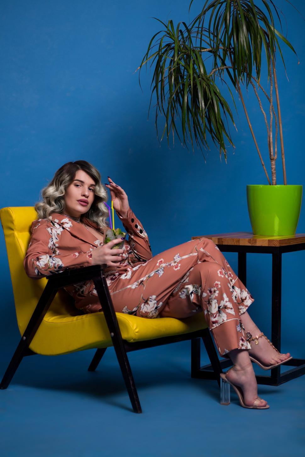 Free Image of Stylish woman lounging in yellow chair 