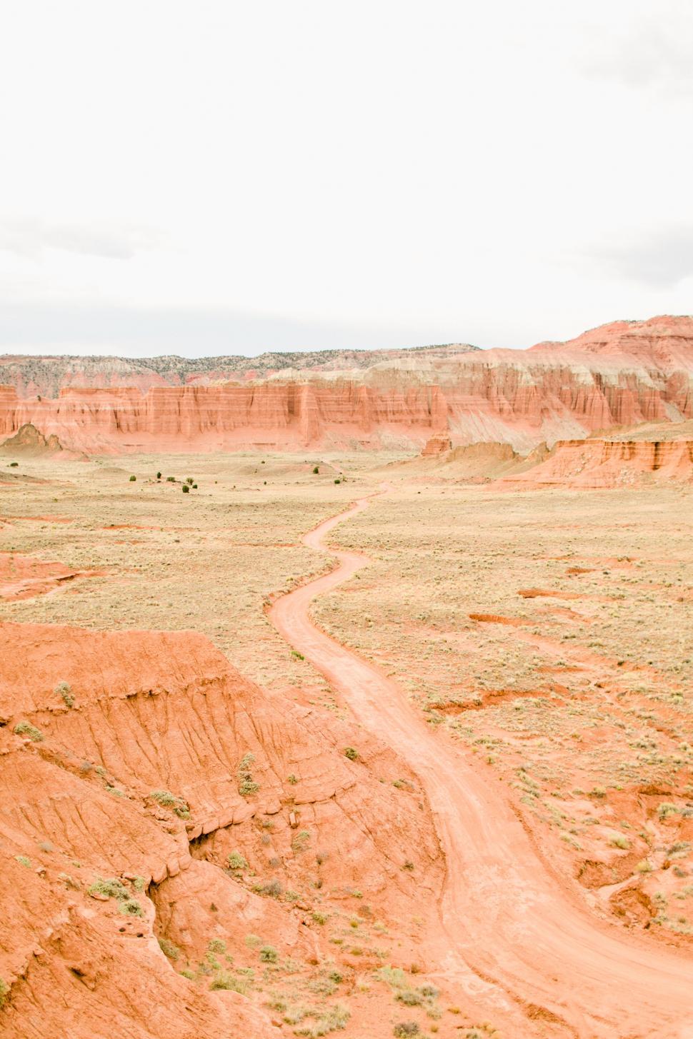 Free Image of Red desert landscape with winding dirt road 