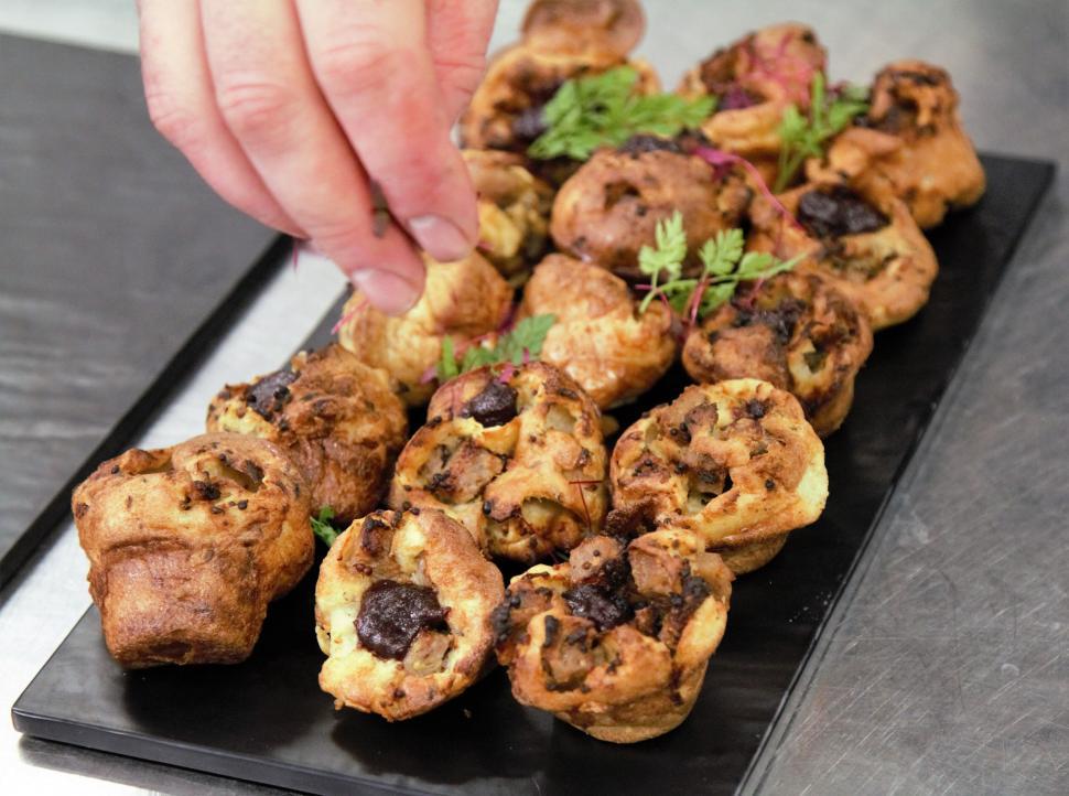 Free Image of Hand placing savory pastry on a plate 