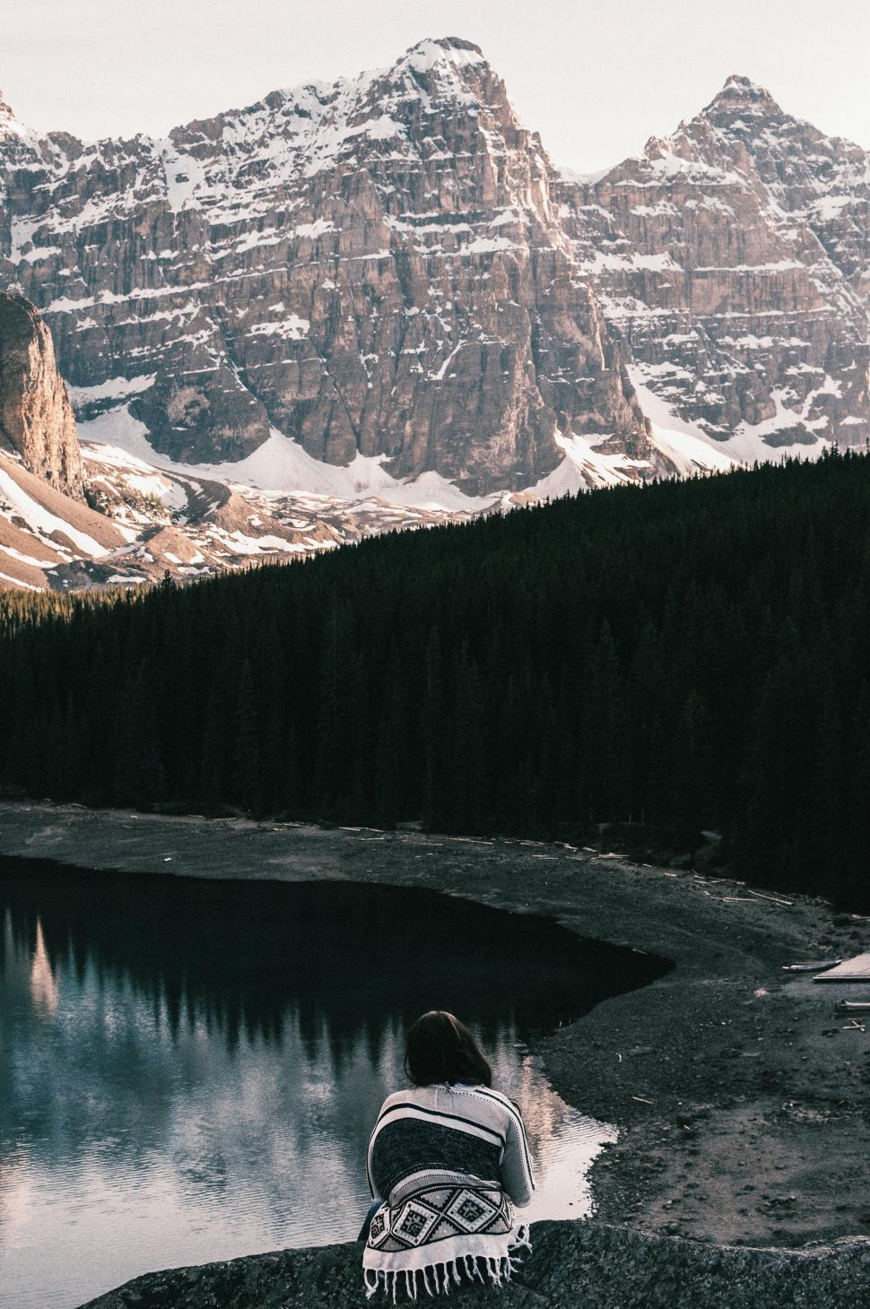 Free Image of Solitary woman by mountain lake at dusk 
