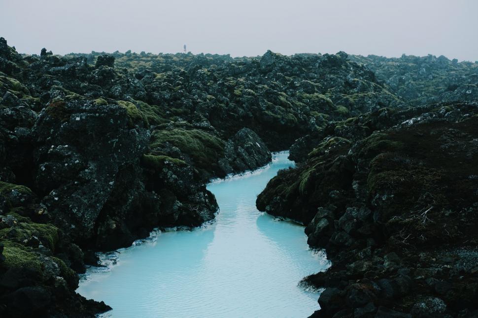Free Image of Mystical blue lagoon surrounded by volcanic rocks 