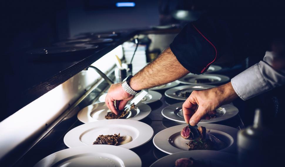 Free Image of Chef plating dishes in a kitchen 