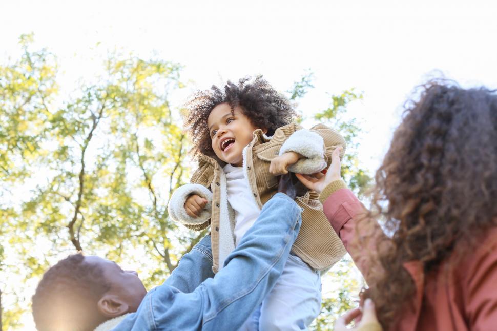 Free Image of Child lifted in the air by parents 