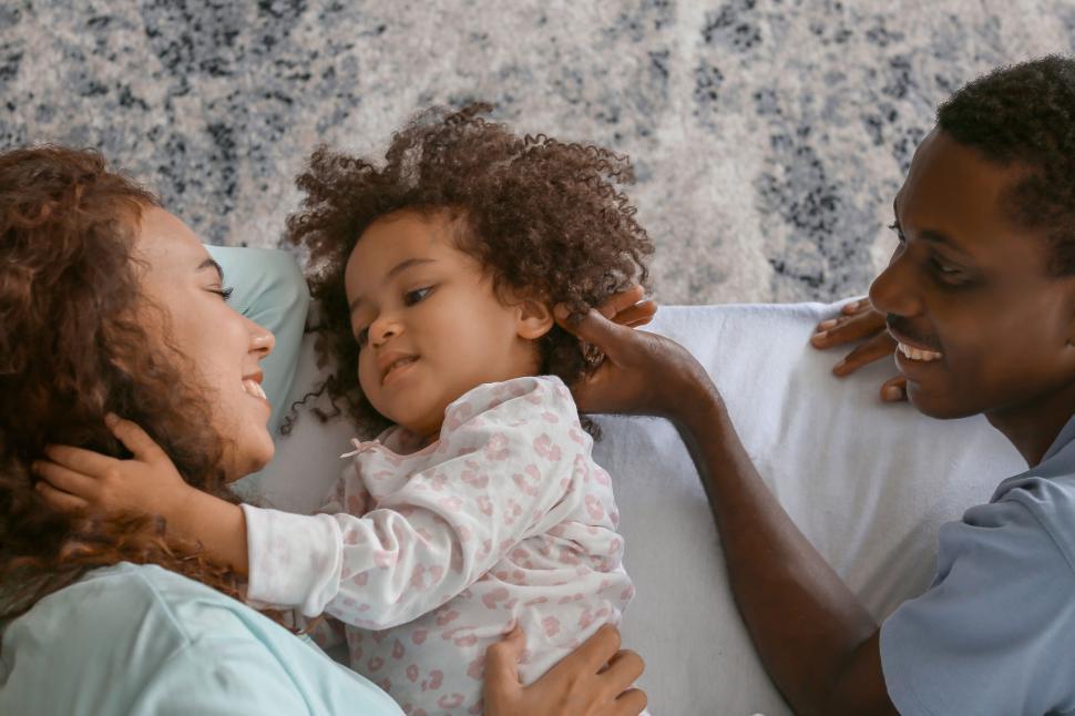 Free Image of Family lying on bed having a fun moment 